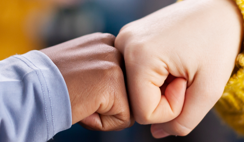 close up african woman friend doing fist bump greeting each other hme living room keeping social distancing as safety precaution global pandemic with coronavirus 1 e1721230291529